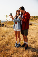 Couple having video call using smart phone while hiking in nature