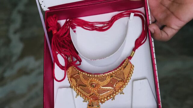 Traditional bridal gold jewelry set against a red velvet gift box