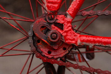 Obraz premium Macro view of rusty bicycle drivetrain with red frame and frosty metal parts.