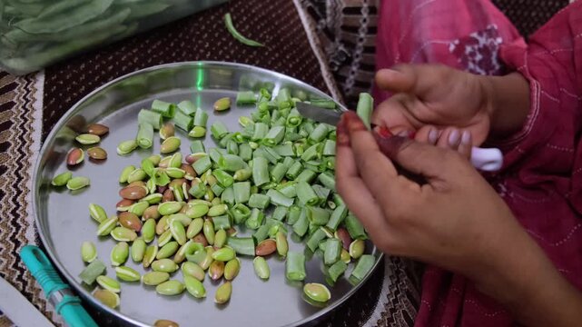 woman hands shelling and cutting green flat beans