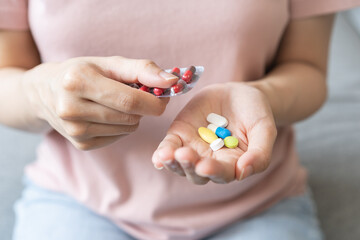 Sick ill asian young woman, girl hand taking tablet pill capsule out from blister pack, painkiller...