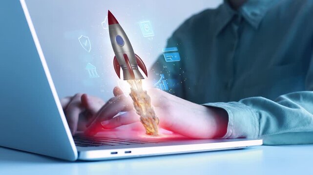 Person works on laptop with rocket launching graphic showing technology and creativity in a modern workspace setting.