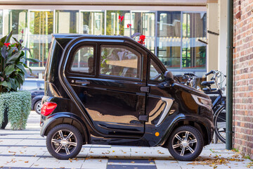 Fototapeta na wymiar Parked electric micro car in a city center