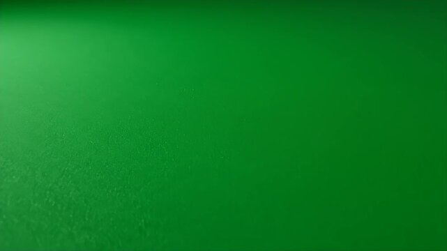 An abstract image features a textured green surface with subtle light and shadow variations