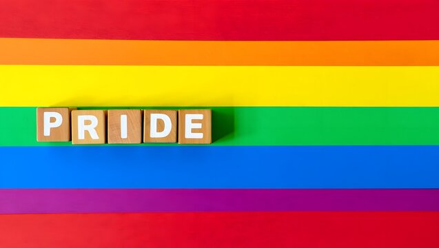 Colorful Pride Flag Background with Wooden Blocks Spelling Pride