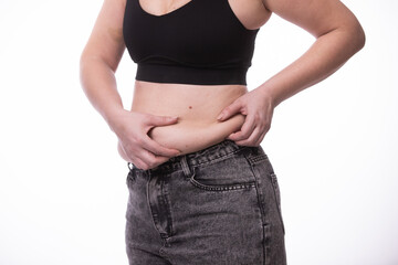 Naklejka premium Fat woman trying to zip up her jeans pants. Women's health. Women body fat belly. Obese woman hand holding excessive belly fat. Diet lifestyle concept, healthy stomach muscle.