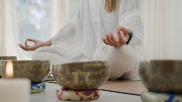 Tibetan singing bowl sound healing meditation guiding woman yoga pose in calm studio with soft light, peaceful wellness ritual for inner peace, mindful focus, spiritual relaxation