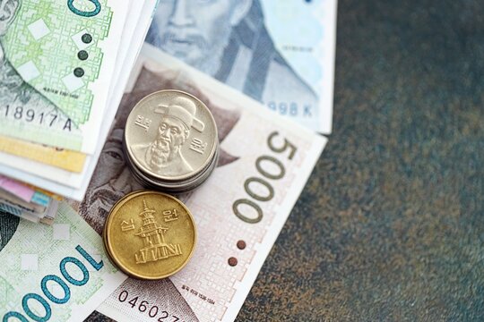 South Korean won money bills and jeon coins pile on table. South Korea coins on banknotes of KRW currency close up. Concept of business, taxes and banking in South Korea