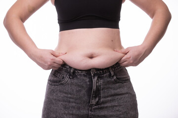Naklejka premium Fat woman trying to zip up her jeans pants. Women's health. Women body fat belly. Obese woman hand holding excessive belly fat. Diet lifestyle concept, healthy stomach muscle.
