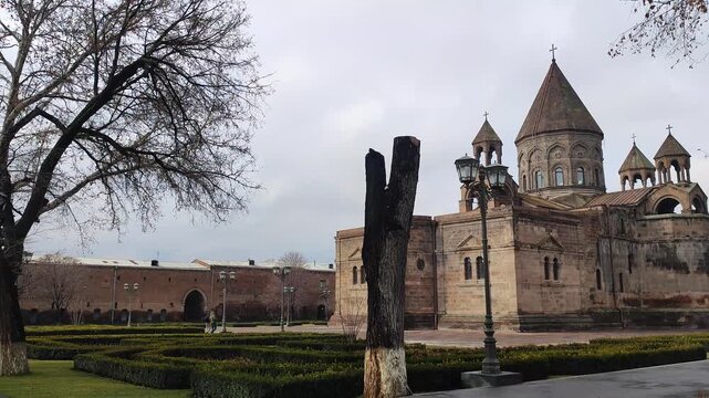 A panoramic view of a historic stone church or cathedral with intricate architectural details։ The Mother Cathedral in early spring