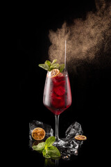 Red cocktail with orange and green leaf on Black Background, single cocktail in a glass  © Marta  Maksymiv