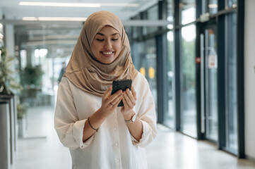 Fototapeta premium Woman in traditional Muslim clothing is indoors in the business building