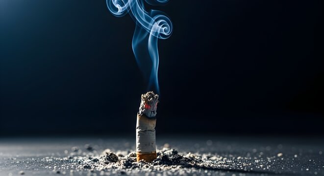 A cigarette butt smoldering in the dark with smoke rising