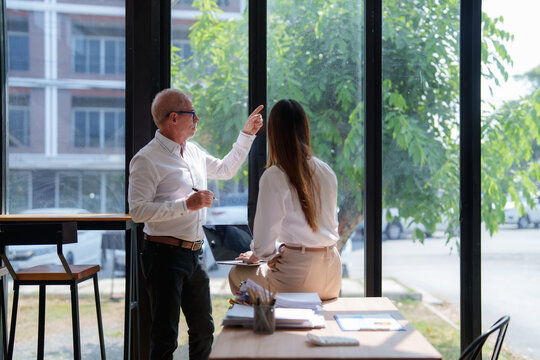 Business mentor guiding young woman in collaboration