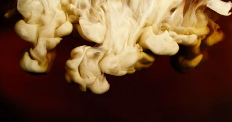 Abstract macro of milk mixing with coffee creating flowing creamy patterns and fluid shapes. Swirling liquid forms soft textures and organic motion, forming a dramatic beverage background. © Jag_cz