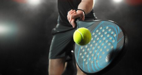 Dynamic action shot of a padel player hitting a yellow ball with a racket during a match. Speed and power, capturing the energy and intensity of modern racket sports © Jag_cz