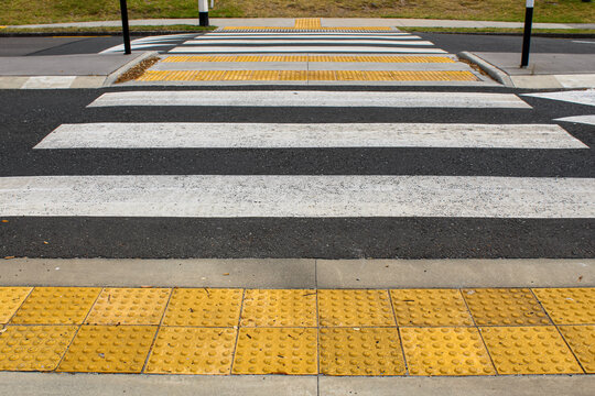 low angle view of a pedestrian crossing withtactile paving tiles. raised truncated domes with a detectable warning surface for visually impaired pedestrians. transportation background