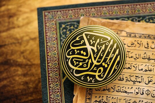 Sign with Al Quran inscription on Muslim holy book in mosque. Details of arabic calligraphy on sticker. Concept of Islam religion and praying in arabic countries