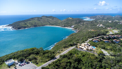 Obraz premium Drone view of João Fernandes neighborhood in Búzios with Praia Grande and cruise ship in turquoise ocean – tropical coastal scenery and seaside tourism