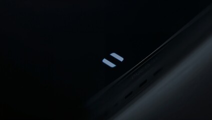 Naklejka premium Displaying glossy device screen showing pause icon in dim studio closeup, bezel vents, copy space