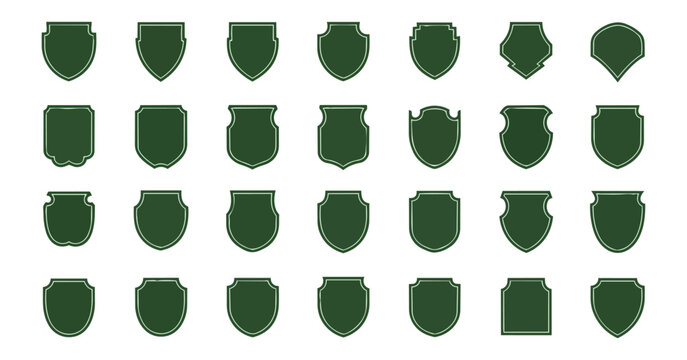 Collection of green shield silhouettes on black background for design