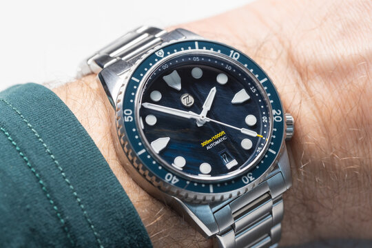 Singapore - April 17, 2025: Waterproof dive watch Zelos Mako V3 300m Diver Falcons Eye is on male wrist, macro photo with selective soft focus