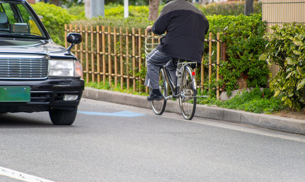 逆走する自転車とすれ違う自動車