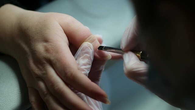 Close-up of a woman receiving a professional hand and nail manicure at a beauty salon. Focus on female hands, skincare, and nail care treatment. High quality 4k footage