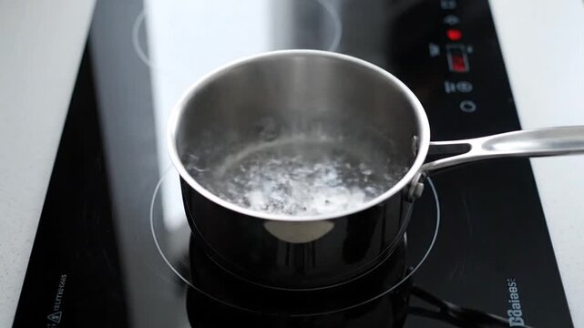 A sequence of images shows a saucepan on a stovetop with water boiling, bubbles rising and steam forming, indicating heating process from start to near boiling.