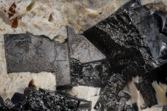 Macro image of perovskite black cubic crystal embedded in calcite white matrix from Khatanga River, Siberia, via microscope, 10x magnification, 3.6mm field of view