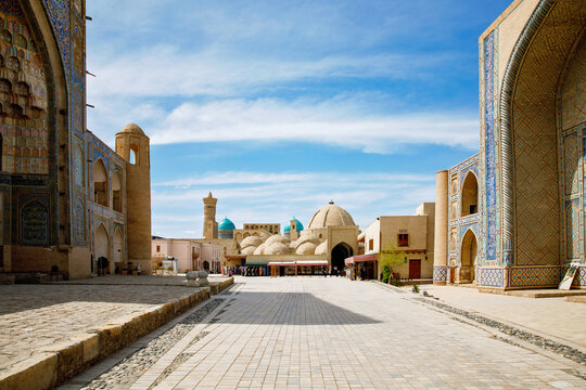 Kosh Madrasah complex in Bukhara with Ulugh Beg and Abdulaziz Khan Madrasas framing Toki Zargaron domes, historic Islamic architecture