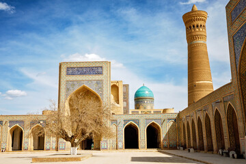 Fototapeta premium Poi Kalyan complex in Bukhara, Uzbekistan, with Kalyan Mosque, Mir-i-Arab Madrasa and iconic minaret under blue sky
