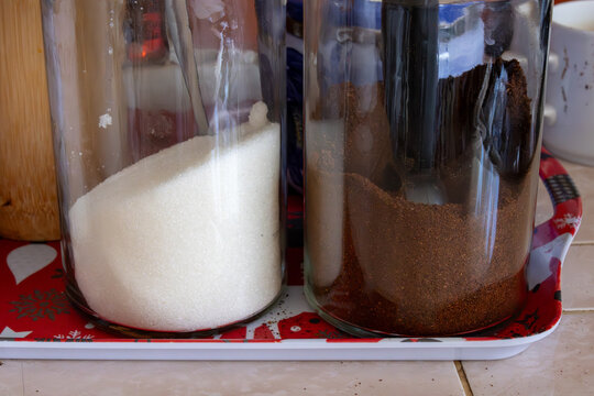 Glass jars with sugar and ground coffee on kitchen tray