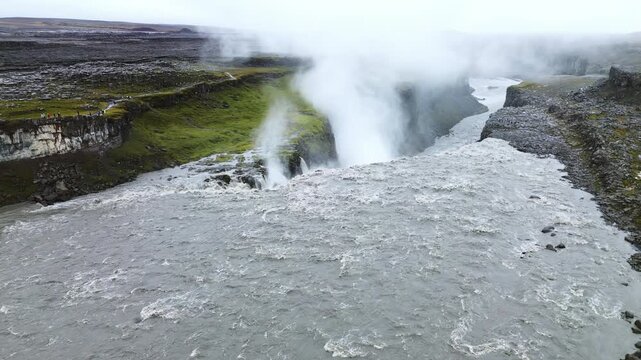 Aerial drone view of Selfoss waterfall upstream from Dettifoss. The wide horseshoe shaped cascade flows over layered basalt cliffs into a rugged canyon landscape carved by ancient glacial floods