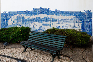 Weathered, green bench and blue and white ceramic tile mural in a park in Lisbon, Portugal. © Yehoshua Halevi