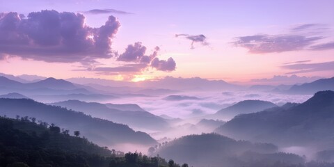 Fototapeta premium Mountains emerge from mist. Soft light paints sky, clouds, hills. Peaceful scene evokes calm, quiet beauty. Natures grandeur displayed.