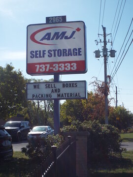 Ottawa, Ontario, Canada-July 21, 2025: A pylon sign for "AMJ Self Storage" at 2965 Bank Street advertises secure storage units, boxes, and various packing materials.