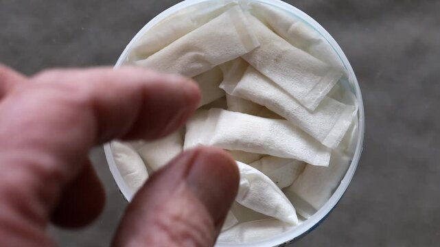 Stockholm, Sweden A man reaches for pouch smokeless tobacco in a plastic tin. 