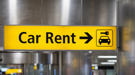 Yellow car rental sign with arrow and icon indicating direction to services