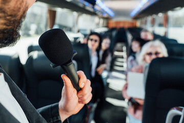Tour guide speaks to group on the bus during a city exploration trip © Maria