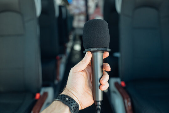 Bus microphone is held in a hand inside the vehicle