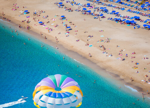Flying on a colorful parachute behind a boat on a summer holiday by the sea in the resort - Alanya, Turkey