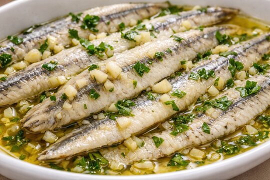 Boquerones en Vinagre mit Knoblauch, Petersilie und Oliven&ouml;l Nahaufnahme
Nahaufnahme von Boquerones en Vinagre mit Knoblauch, Petersilie und Oliven&ouml;l.