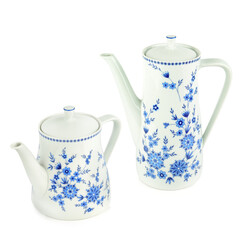 Fototapeta premium Elegant white ceramic teapot and coffee pot set with blue floral pattern isolated on white background. Vintage porcelain tea set with floral ornament. Classic kitchenware for tea party.