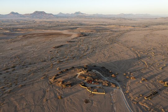 The Doro Nawas Camp and arid desert plains at the edge of the dry river bed of the Aba-Huab river, aerial view, drone shot, Damaraland, Kunene Region, Namibia