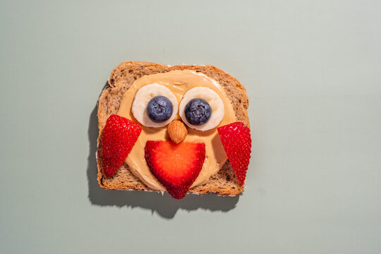 Cute food art with peanut butter and fruit on whole grain bread for a fun snack time