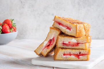 Strawberry and cream sandwich stacked on a plate in a kitchen setting during the day