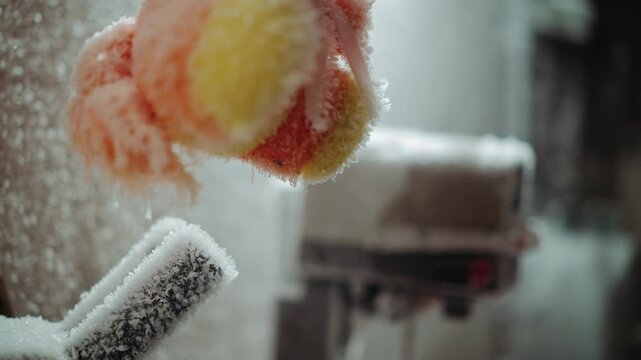 Frozen colorful pompom toy hovering over frostcovered miniature vehicle, closeup of crystallized fibers and icy dust, soft texture turned brittle, muted light evoking nostalgic loss after nuclear