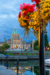Fototapeta premium Victoria Parliament Building Inner Harbour Morning Flower Basket. Flower basket over Victoria's Inner Harbor and marina in downtown Victoria. The historic Legislative Building in the background. 