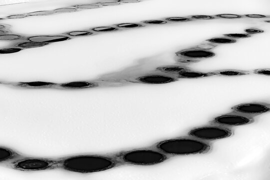 Snowy, frozen water surface with air holes, Rietzlern, Kleinwalsertal, Vorarlberg, Austria